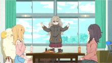 a girl in a hoodie stands in front of a table with a bottle of orange juice on it