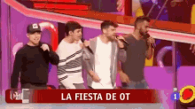 a group of men singing on a stage with the words la fiesta de ot on the screen