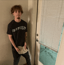 a young man wearing a black shirt that says ' wildflower '