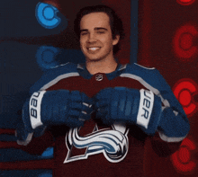 a man wearing a maroon jersey with the letter a on the front