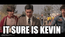 a man in a suit and tie says it sure is kevin while walking with two other men