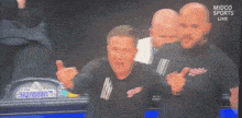 a man wearing a shirt that says bites is cheering in the stands