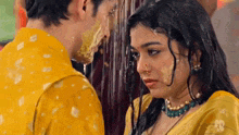 a man and a woman are standing in the rain and the woman is covered in yellow powder
