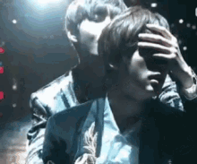a man is kissing another man on the forehead .