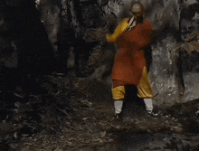 a person in a red and yellow outfit is crawling on the ground
