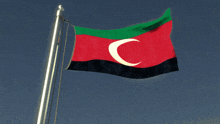 a red green and black flag with the letter c on it