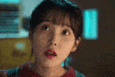 a close up of a girl 's face with a surprised look on her face