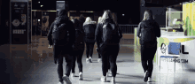 a group of people are walking in front of a table that says firstteamgaming.com