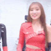 a woman in a red crop top is standing in front of a microphone in a room .