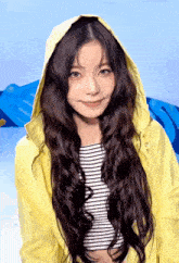 a woman with long hair wearing a yellow jacket and striped shirt
