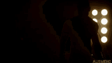 a silhouette of a man standing in a dark room with the word alishmehc on the bottom