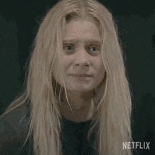 a woman with blonde hair is making a stop sign with her face