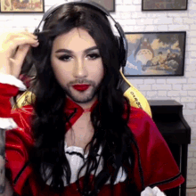 a man with long hair and a beard is wearing headphones and a red shirt that says overwatch