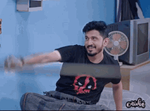 a man wearing a black shirt with a deadpool logo