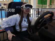 a woman wearing a virtual reality headset is holding a steering wheel in front of a sign that says pni