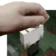 a person 's hand is holding a block in a video game .