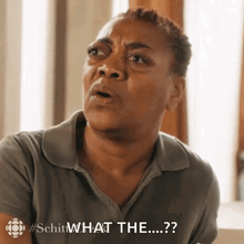 a woman in a grey shirt is making a funny face and says what the ....