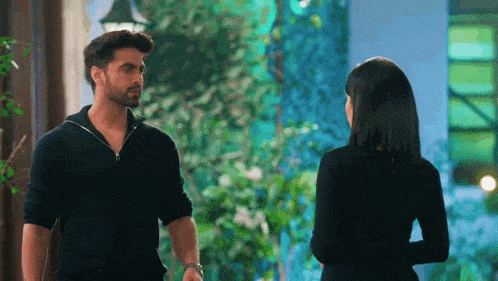 a man and a woman are standing next to each other and talking .