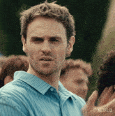 a man in a blue striped shirt has a netflix logo on the bottom right