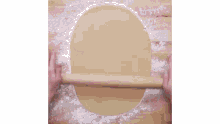 a person is holding a cookie in their hands on a table .