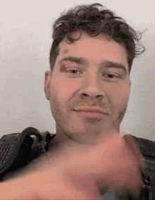 a man with a red spot on his forehead