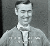 a man in a bow tie is smiling and saying `` you just got mr. rogered '' in a black and white photo .
