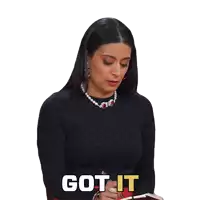 a woman wearing a black sweater and a pearl necklace has the word got it written on her face