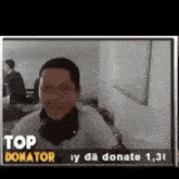 a man wearing headphones is smiling in front of a sign that says " top donator "