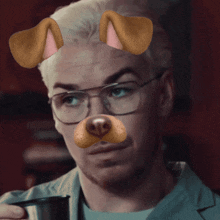 a man wearing glasses and a dog face filter drinks from a mug