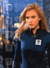 a woman in a superhero suit has a question mark on her chest