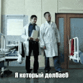 two men in lab coats standing next to each other in a hospital room with russian writing