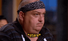 a man with a bandana on his head has the word stare written above him