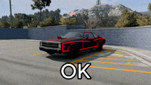 a black and red car is parked in a parking lot with the word ok above it