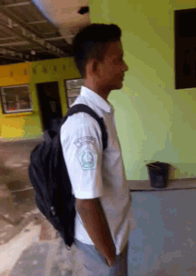a man wearing a white shirt and a black backpack has a badge on his sleeve that says ' a ' on it
