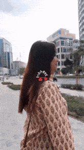 a woman walking down a street with a sticker on her hair that says sad love