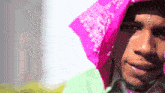 a man wearing a pink bandana and a green shirt