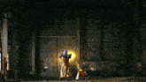 a man in a costume stands in front of a large building with a fire in the background