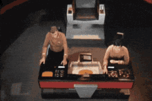 two men are sitting at a table with a calculator that says ' l ' on it