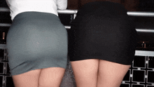 two women are standing next to each other with their skirts down