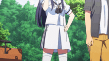 a girl in a white school uniform stands next to a man