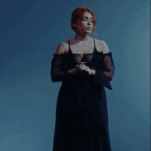 a woman in a black dress is standing in front of a blue background with the word contigo on it