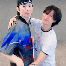 two young men are hugging each other and one of them is wearing a shirt that says always