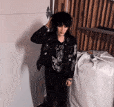 a woman in a black jacket and black pants is standing in front of a white door