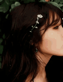 a woman with flowers in her hair is eating a flower