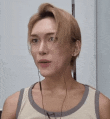a young man wearing headphones is making a funny face .
