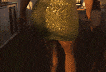 a woman in a green dress stands in front of a building