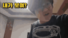 a man wearing glasses and a t-shirt with a circle on it is asking a question in korean