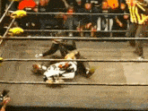 a wrestler is laying on the ground in a ring
