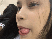 a close up of a woman 's face with her tongue hanging out
