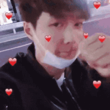 a man wearing a face mask with red hearts on his face